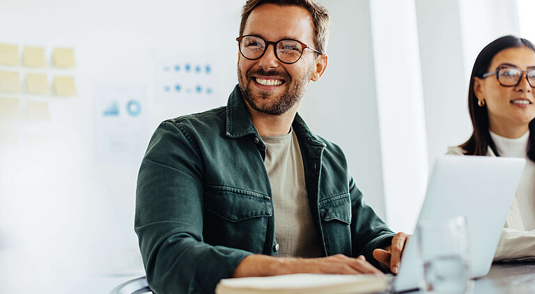 Mann und Frau am Tisch mit Laptop